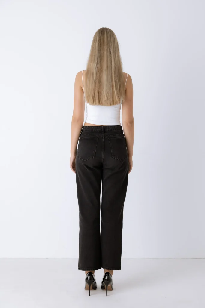 Rückansicht einer Frau in schwarzer Jeans und weißem Top