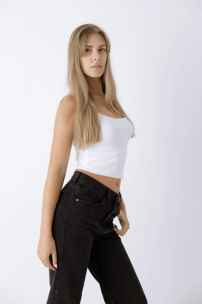 Frau im weißen Crop-Top und schwarzer Jeans