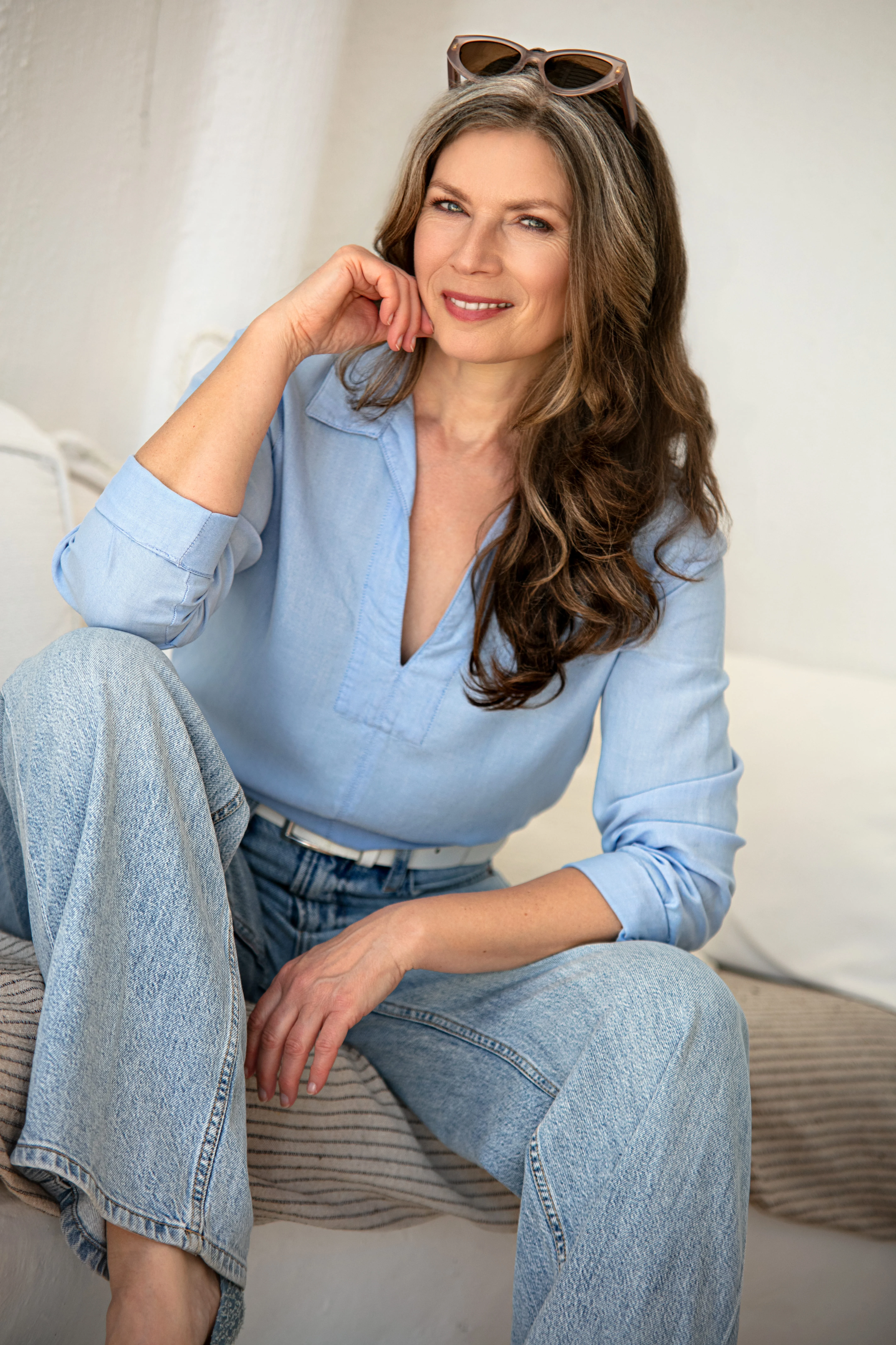 Lächelnde Frau in blauer Bluse und Jeans