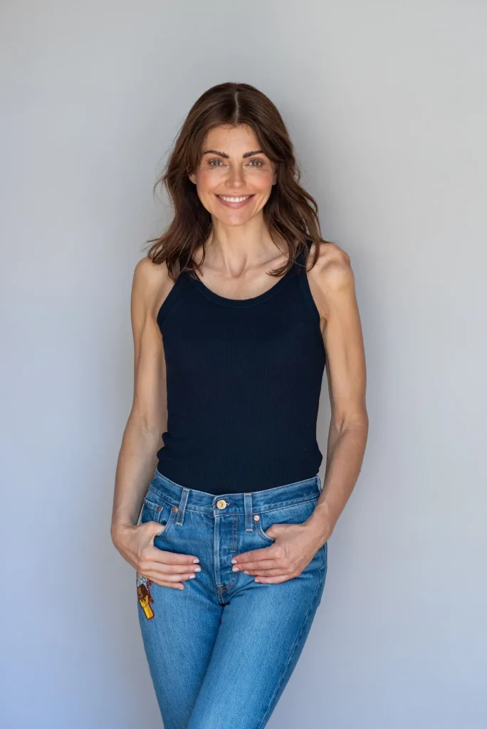 Lächelnde Frau in schwarzem Top und Jeans