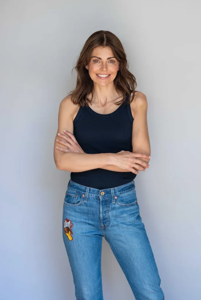 Lächelnde Frau in schwarzem Top und Jeans