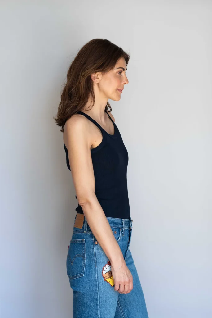 Frau im Profil mit schwarzem Tanktop und Jeans