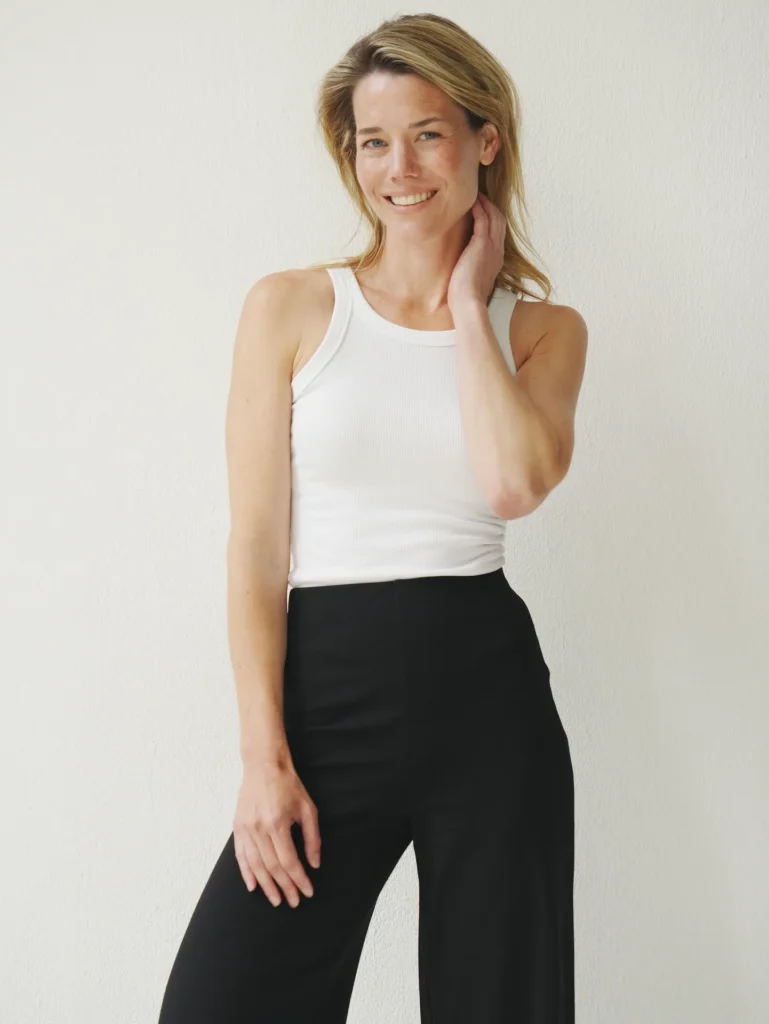 Smiling woman in white tank and black pants