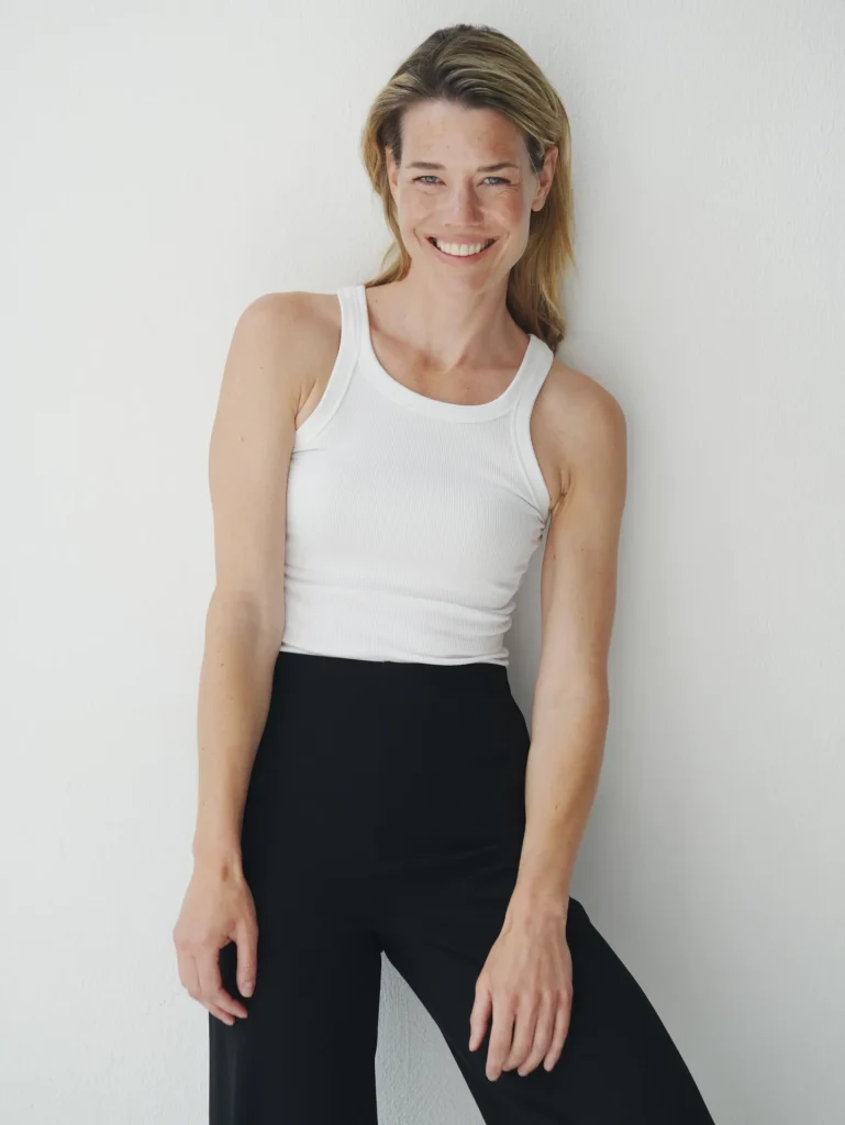 Smiling woman in white tank top indoors