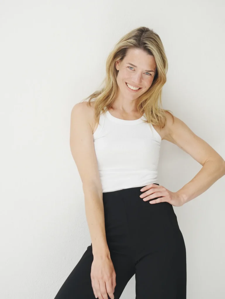Smiling woman in white tank and black pants