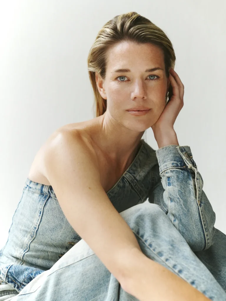 Woman in denim jacket portrait against neutral background