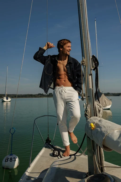 Lachender Mann auf Segelboot bei sonnigem Wetter