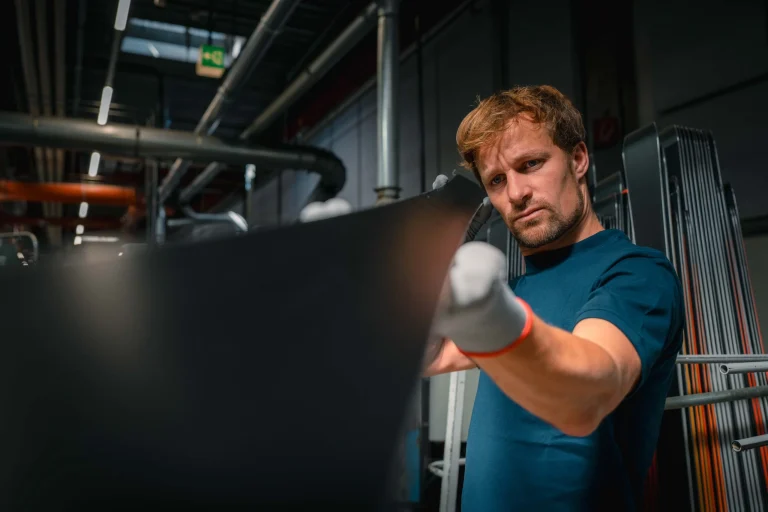Techniker prüft Industrieanlage mit Tablet im Maschinenraum