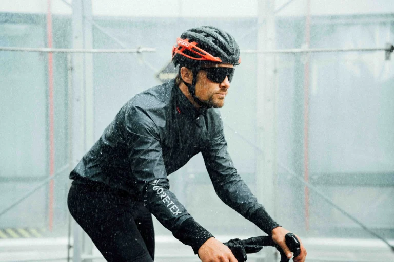 Radfahrer in schwarzer Regenkleidung fährt durch starken Regen