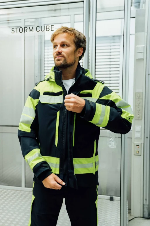 Mann in Warnschutzkleidung vor dem Storm Cube