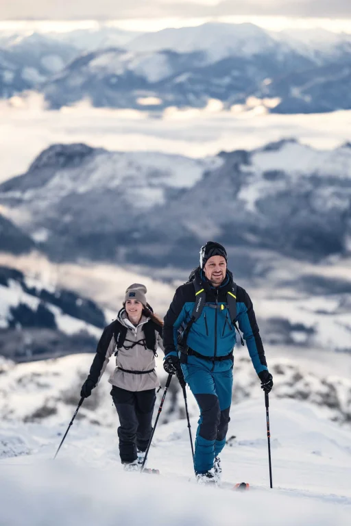 Zwei Skitourengeher steigen durch verschneite Berglandschaft