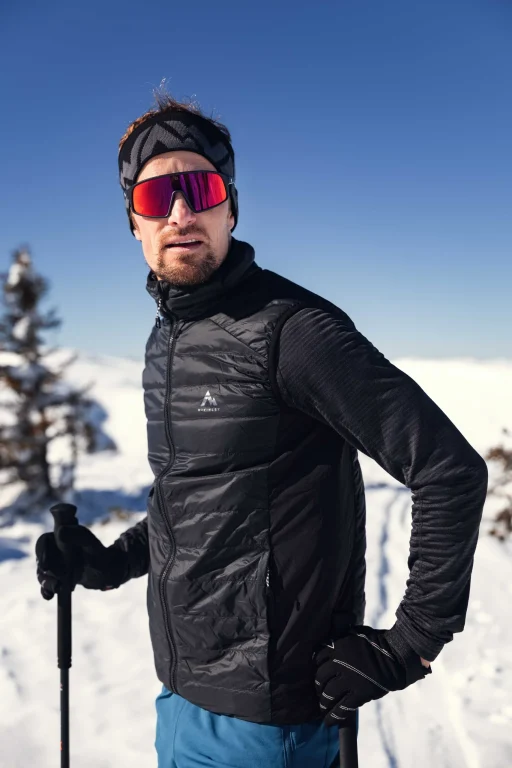 Mann mit Skistöcken in verschneiter Berglandschaft