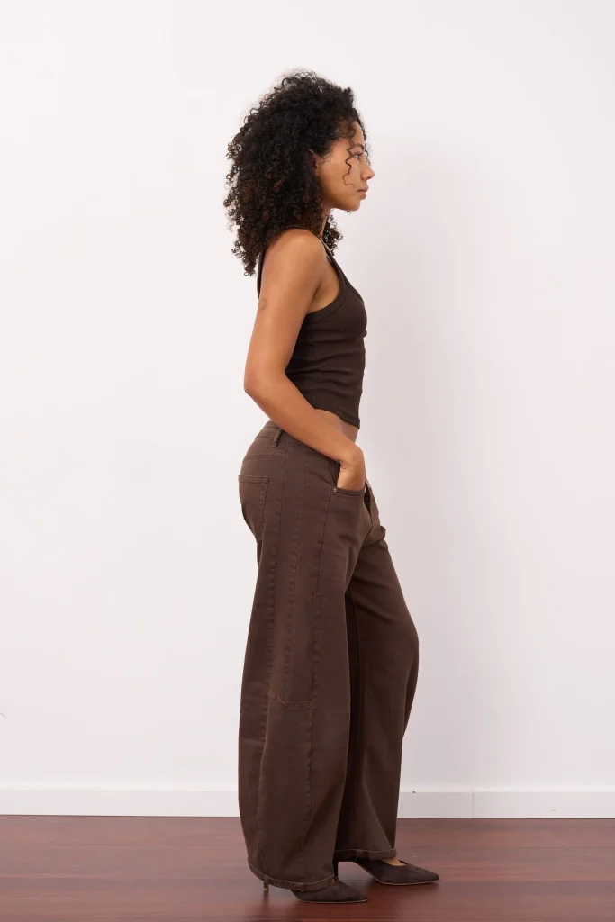 Frau im Profil mit braunem Top und weiter Hose