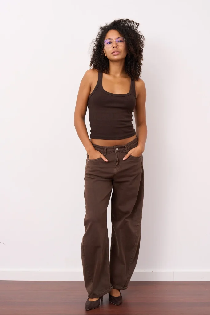 Frau mit Brille in braunem Tanktop und weiter Hose