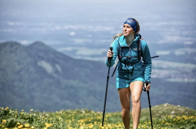 Wanderin mit Trekkingstöcken in Berglandschaft