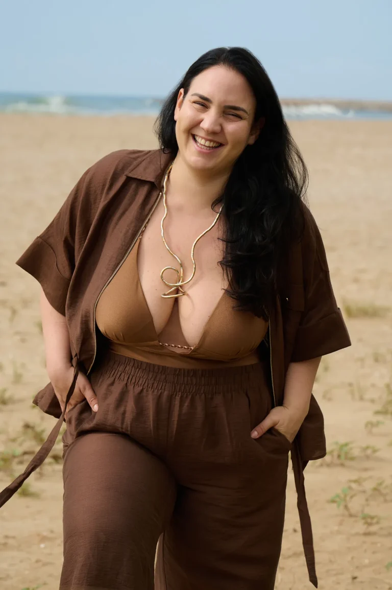 Lächelnde Frau in braunem Outfit am Strand