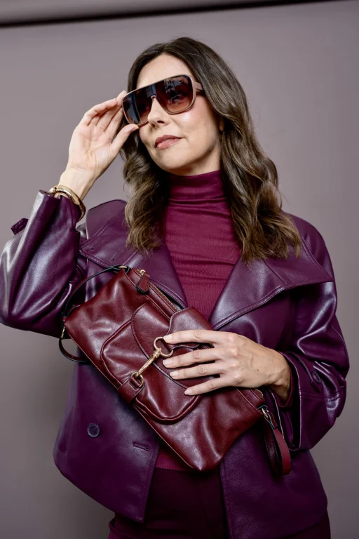 Frau mit Sonnenbrille, Lederjacke und bordeauxroter Handtasche