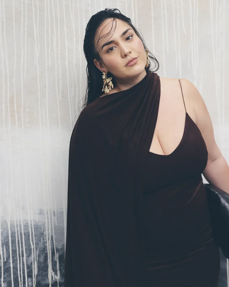 Frau im dunklen One-Shoulder-Kleid mit Goldohrringen