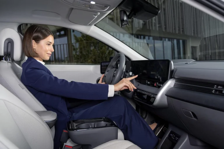 Frau bedient Touchscreen im modernen Auto
