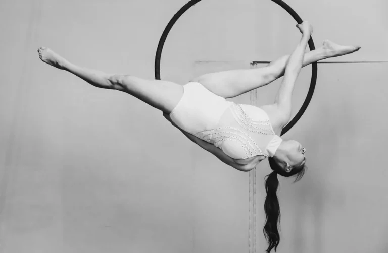 Luftakrobatin zeigt Spagat kopfüber im Aerial Hoop