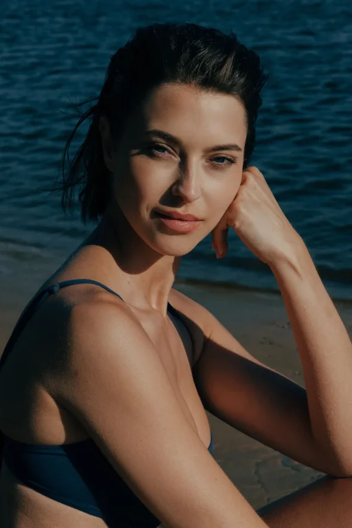 Frau im Bikini am Strand am Wasser