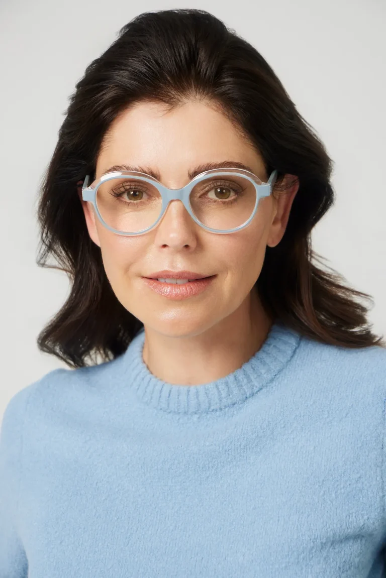 Frau mit hellblauer Brille und Pullover
