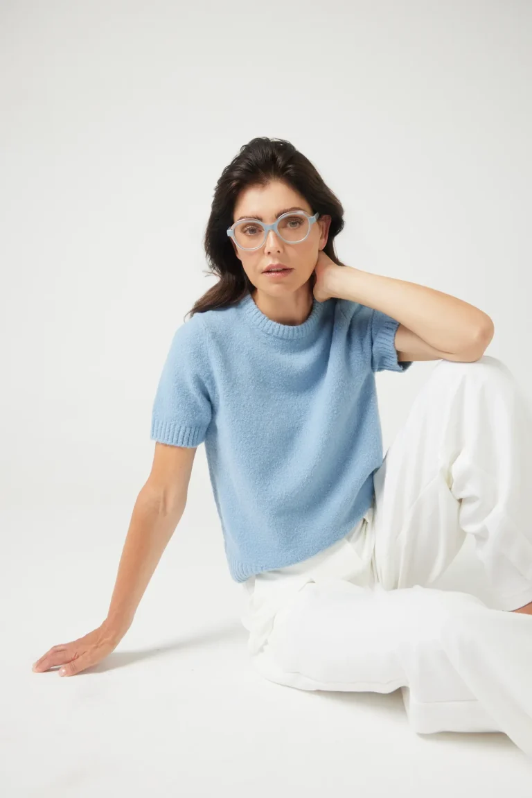 Frau mit blauer Brille und Pullover