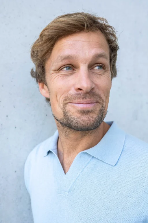 Porträt eines lächelnden Mannes im hellblauen Poloshirt