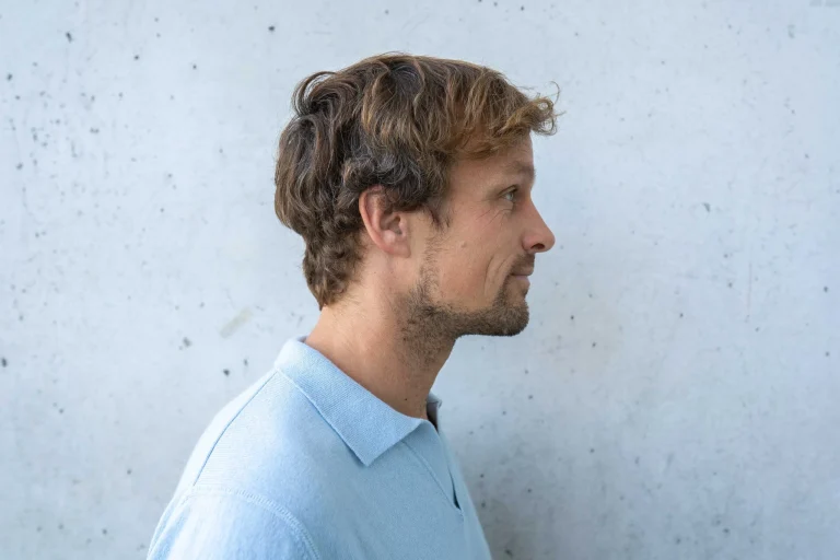 Mann im Profil vor heller Betonwand