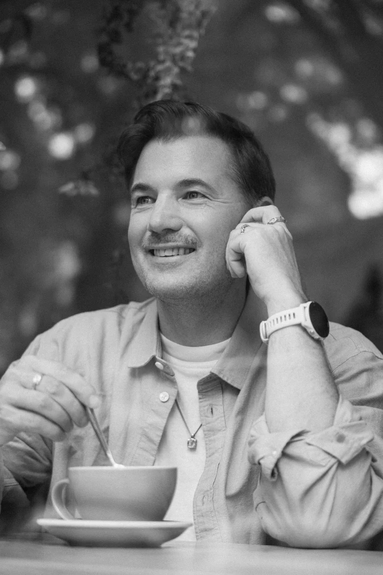 Lächelnder Mann mit Kaffeetasse im Café