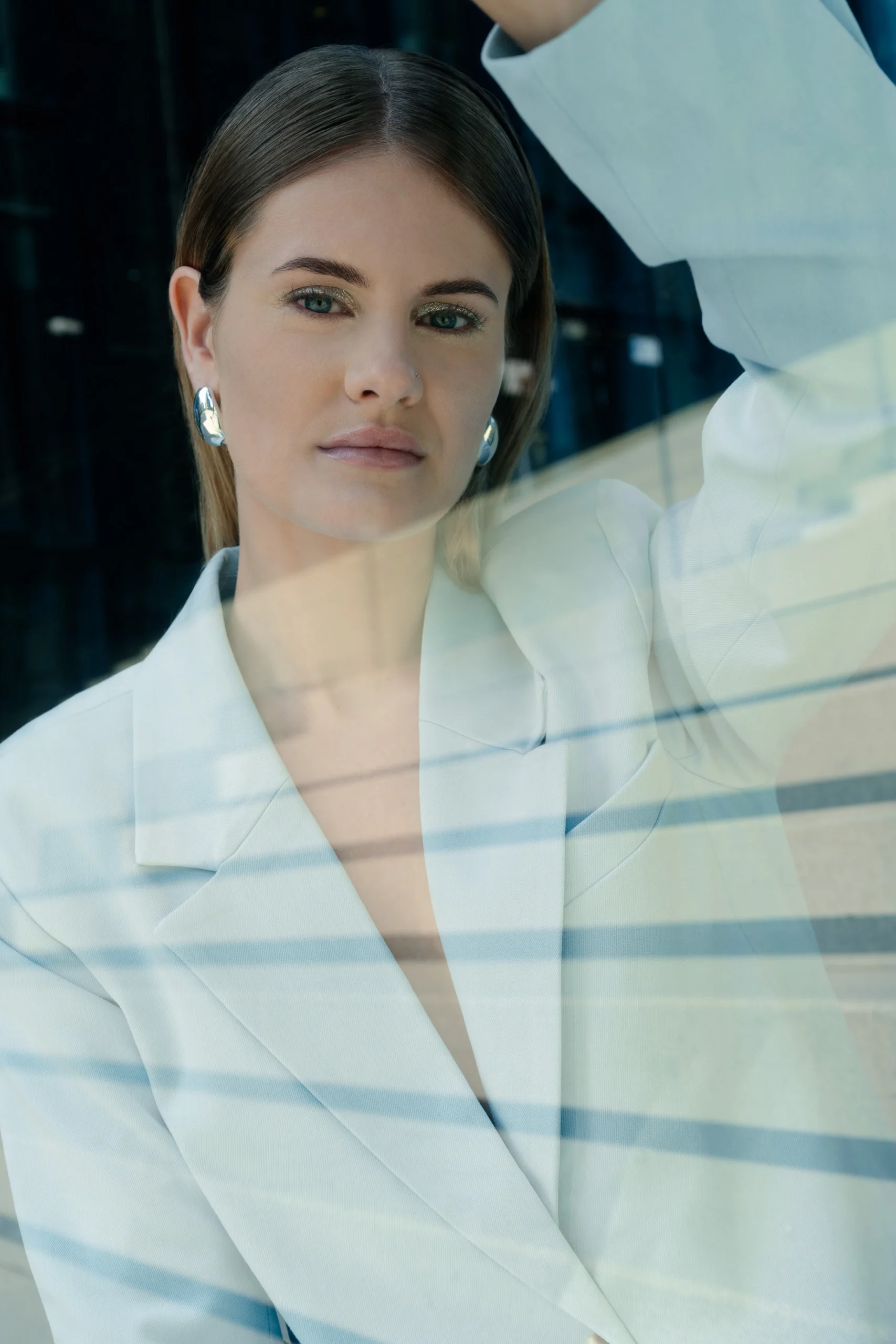 Frau im weißen Blazer hinter Glas