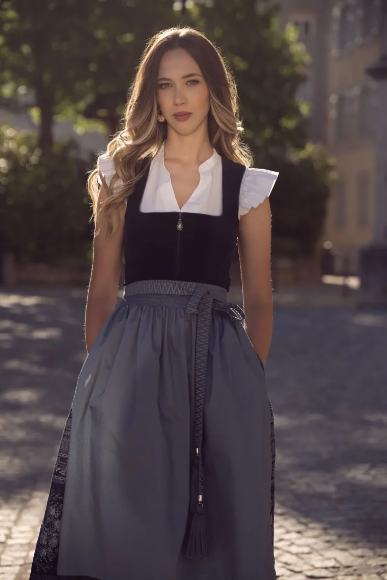 Frau im Dirndl auf sonniger Kopfsteinpflasterstraße