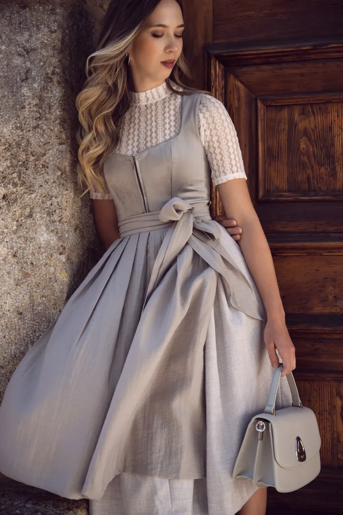 Frau im eleganten Dirndl an Holztür