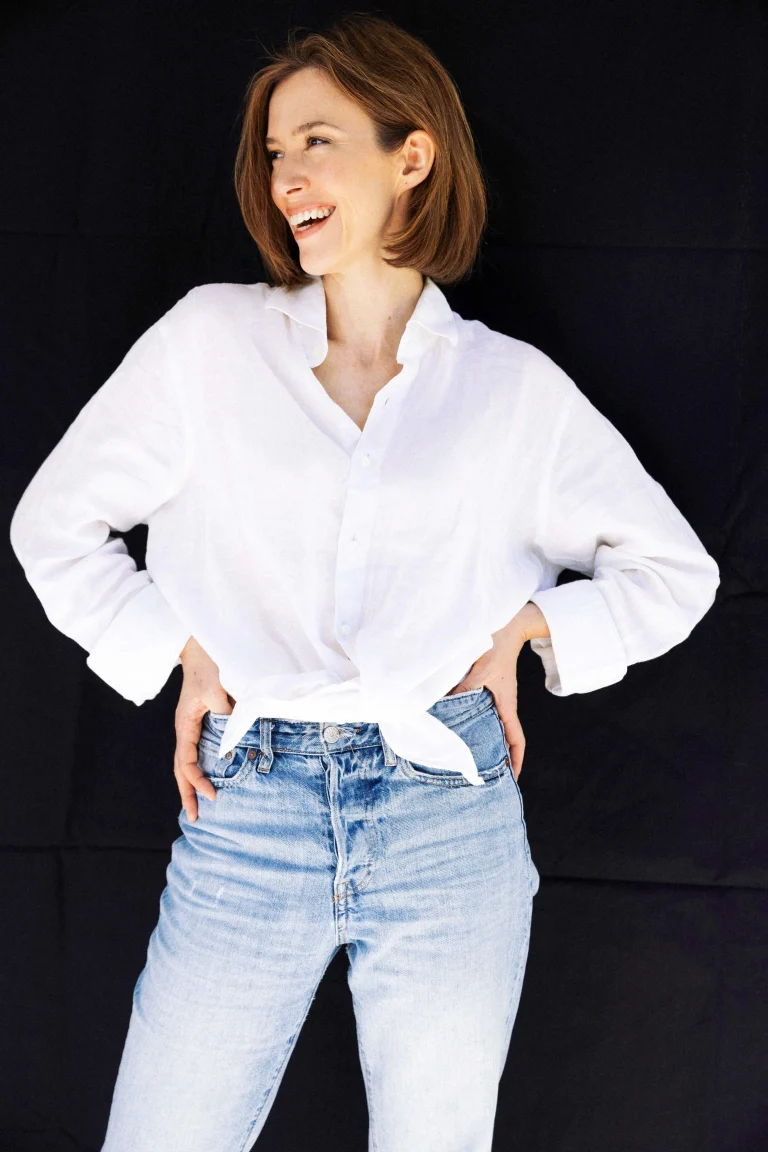 Lächelnde Frau in weißer Bluse und Jeans