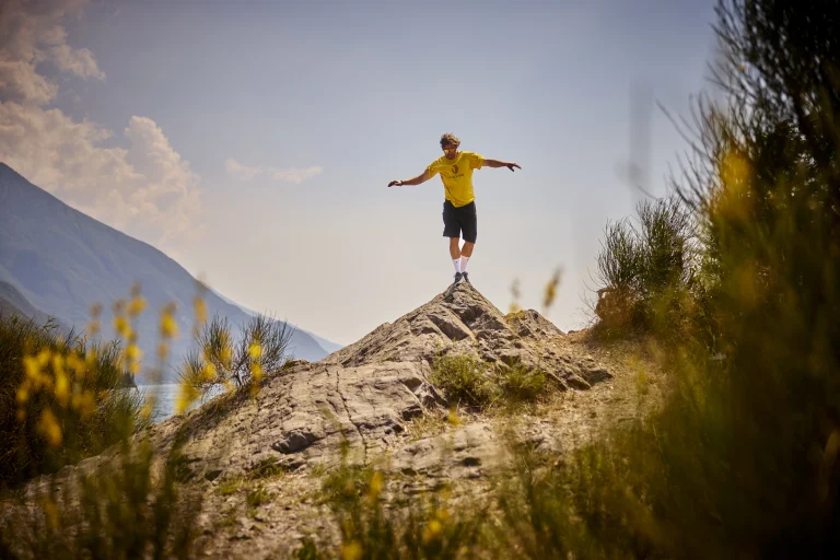 Mann balanciert auf Felsen in Berglandschaft
