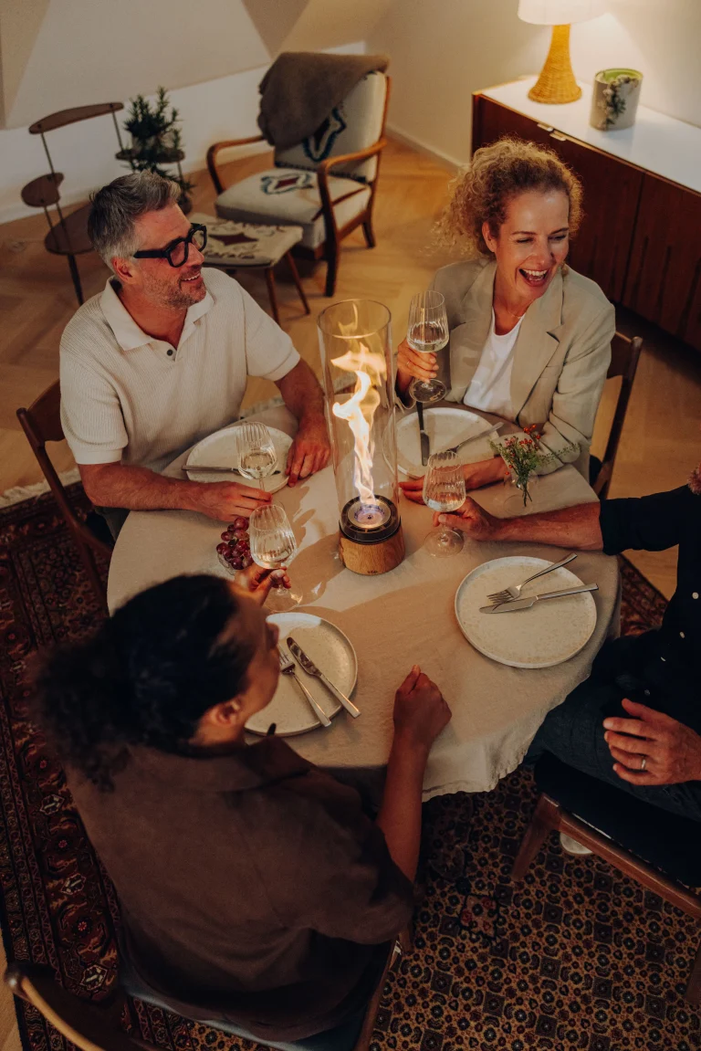Freunde stoßen bei gemütlichem Abendessen mit Wein an