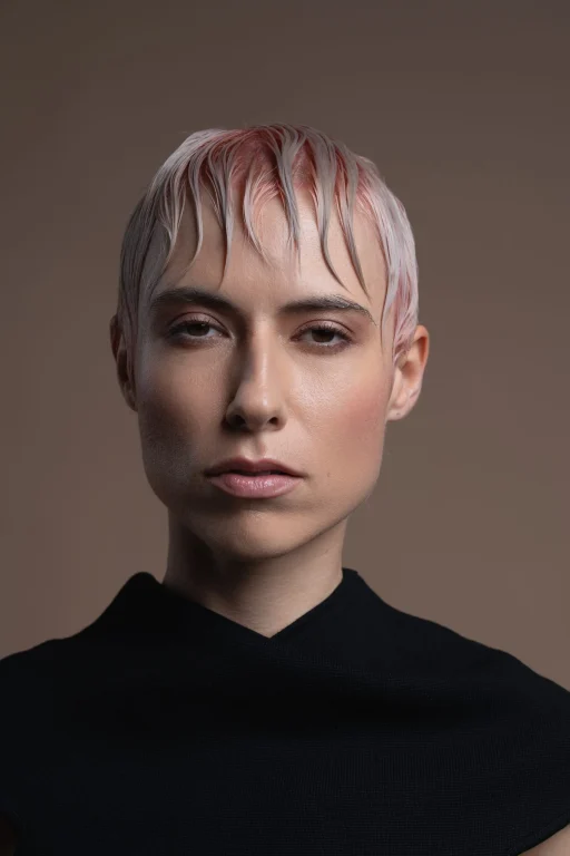 Porträt einer Person mit kurzem rosafarbenem, nassem Haar