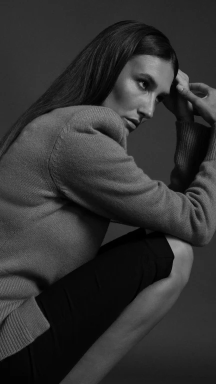 Schwarz-Weiß-Porträt einer nachdenklichen Frau im Strickpullover