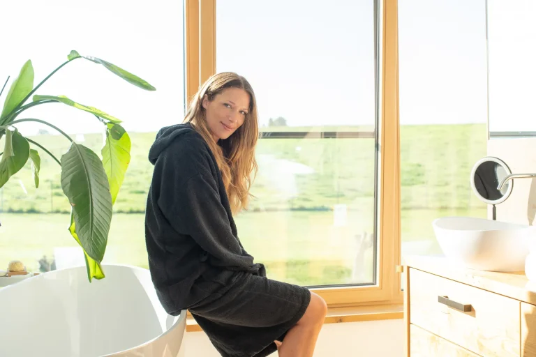 Frau im Bademantel im hellen Badezimmer