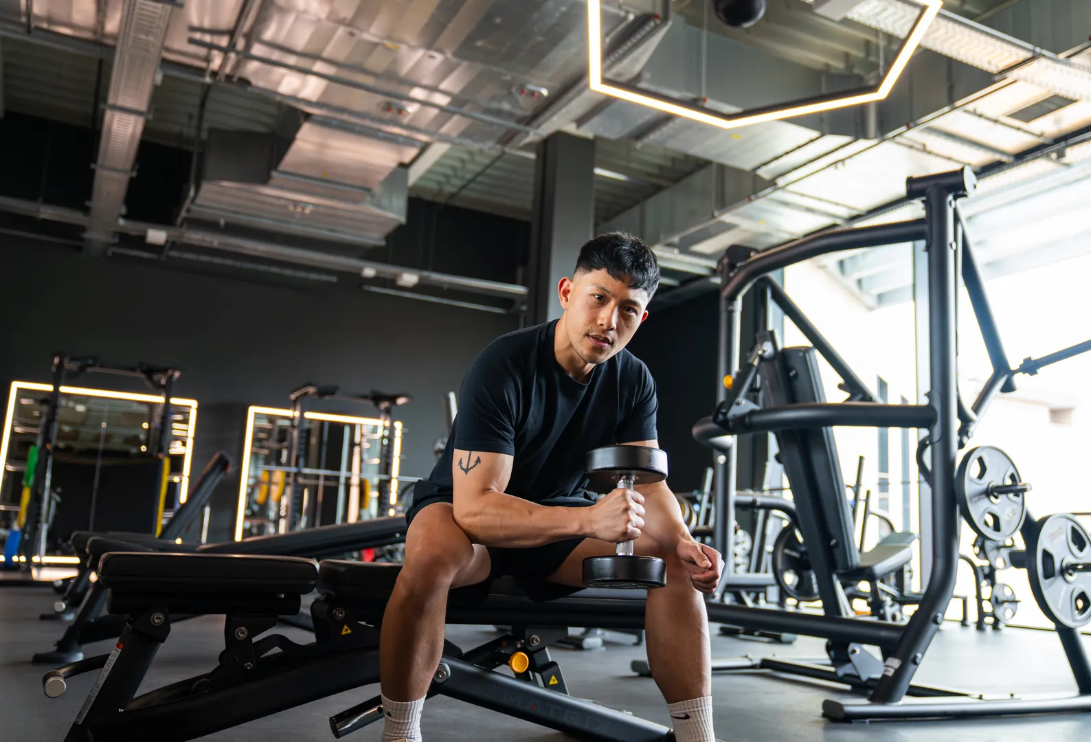 Mann trainiert mit Kurzhantel im Fitnessstudio