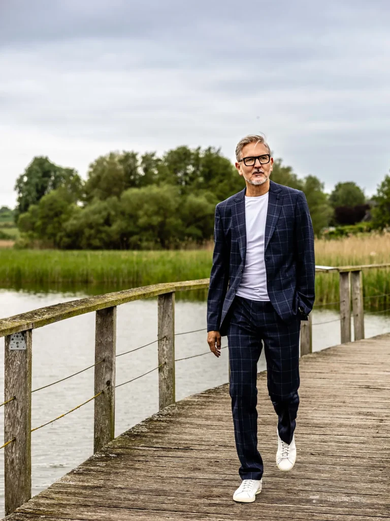 Eleganter Mann im Anzug auf Holzsteg am See