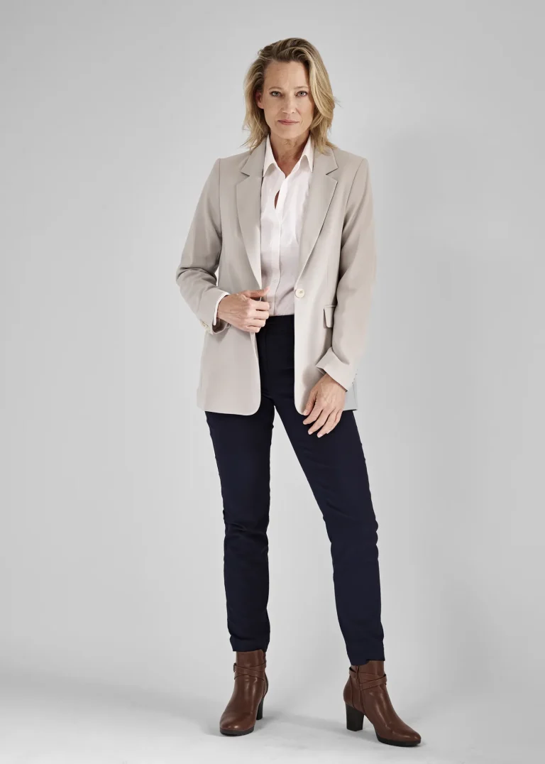 Frau im beigen Blazer und braunen Stiefeletten