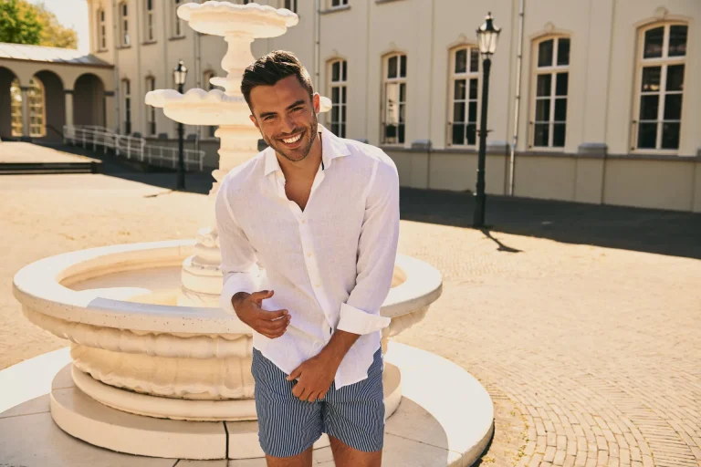 Smiling man standing by courtyard fountain