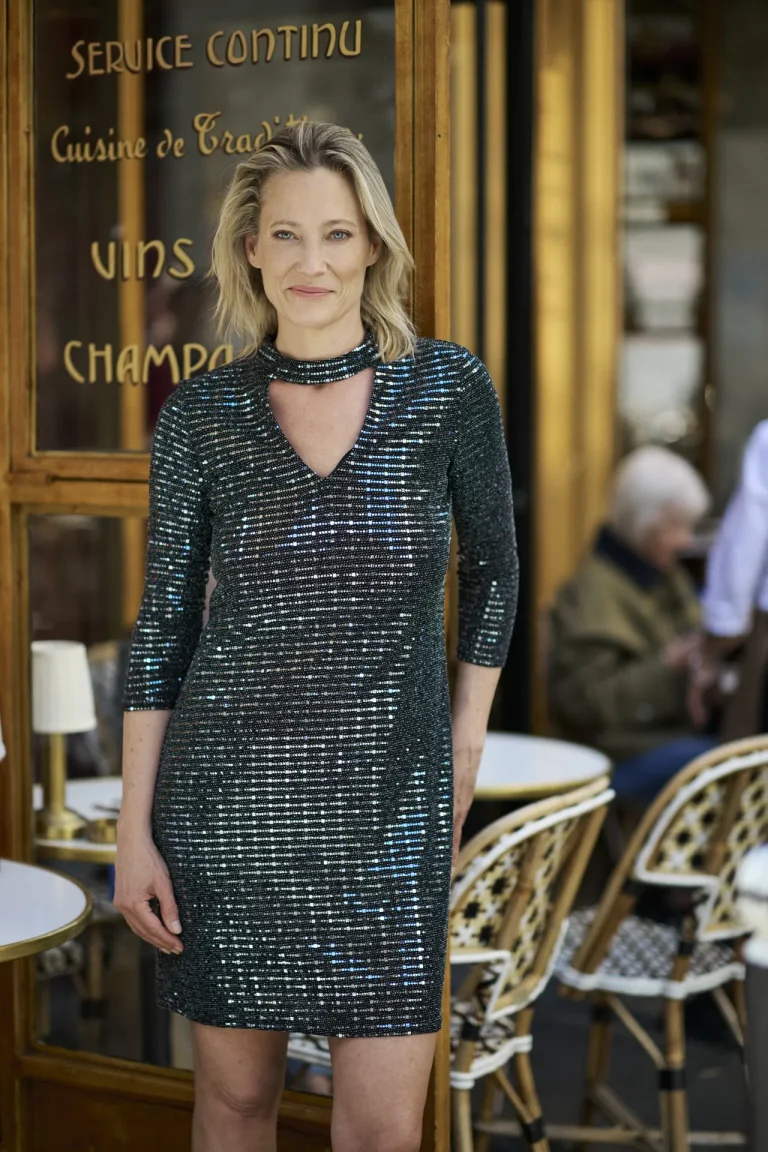 Frau im glitzernden Kleid vor französischem Café