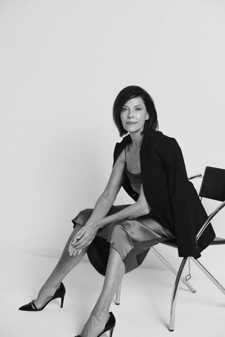 Elegante Frau sitzt auf Stuhl im Studio
