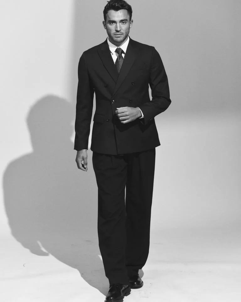 Man in double-breasted suit walking in studio