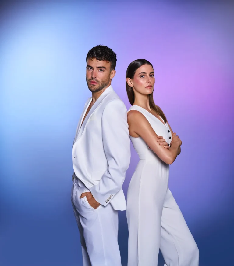 Stylish couple posing back-to-back in white outfits