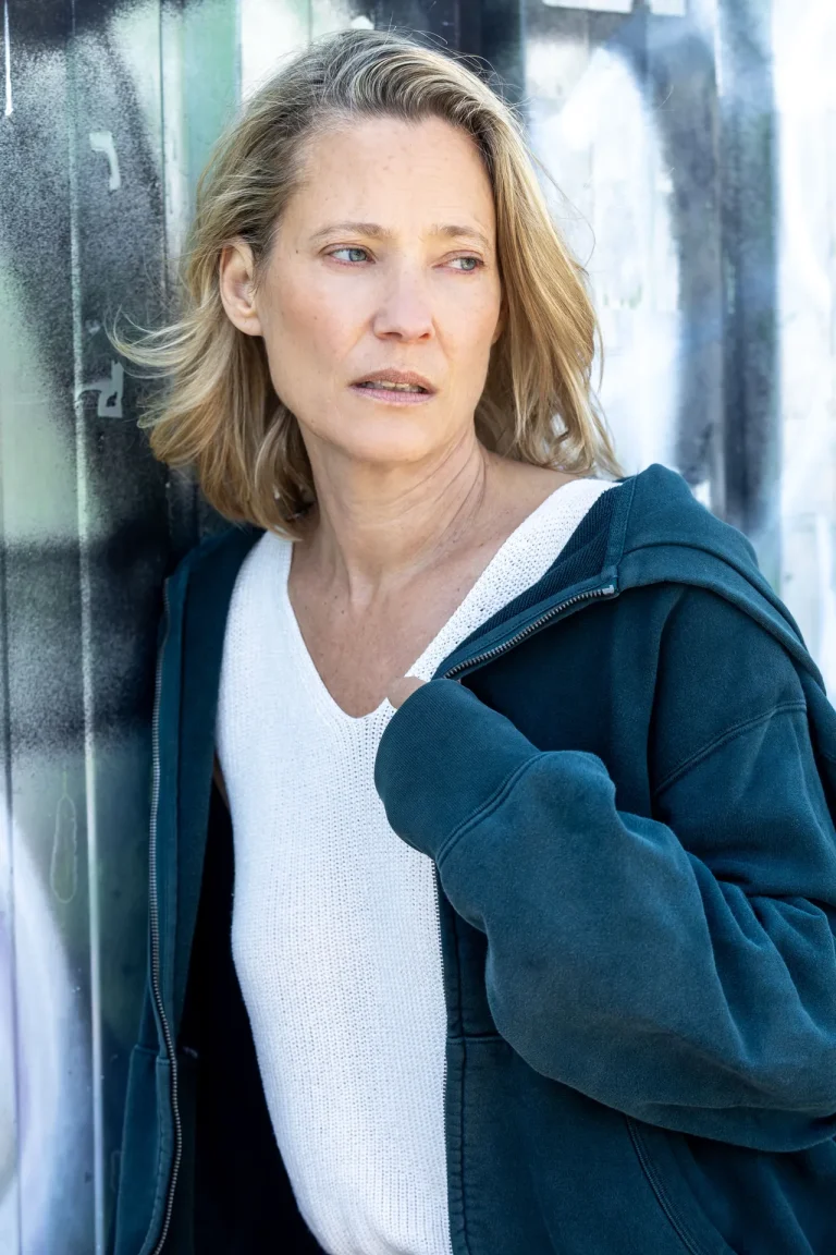 Nachdenkliche Frau lehnt an urbaner Wand