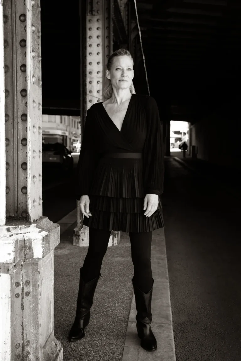 Frau in schwarzem Kleid unter Stahlbrücke