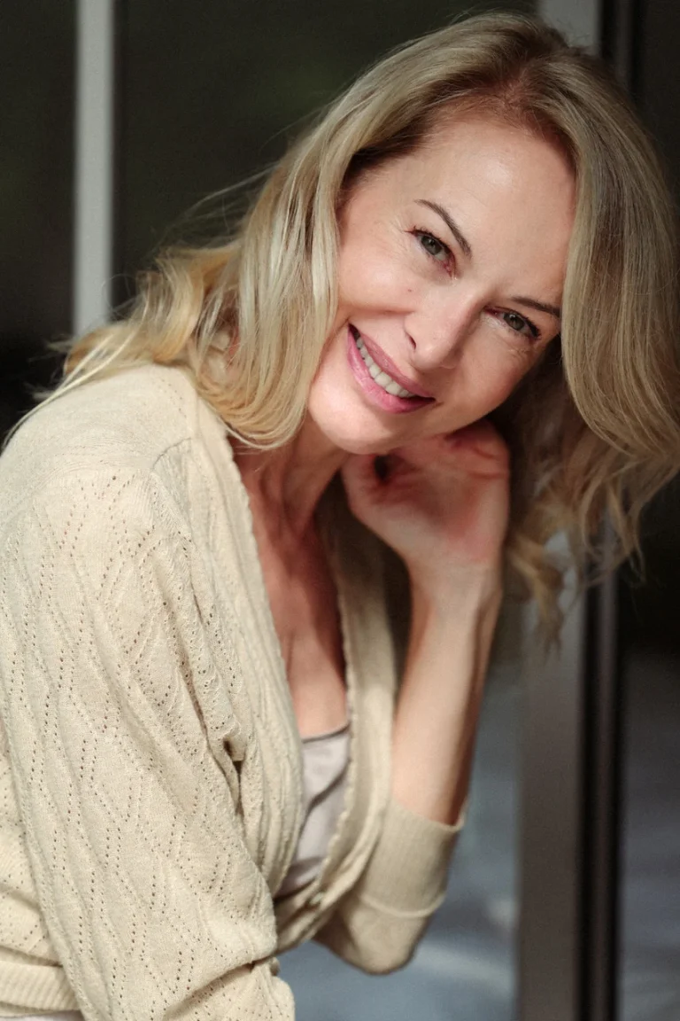 Lächelnde blonde Frau in beigem Cardigan